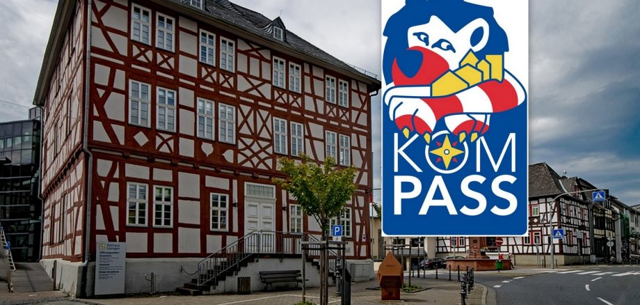 Das Usinger Rathaus in Richtung der Hauptstraße. Rechts ist das Logo von Kompass mit einem blau, rot, weißem Löwe abgebildet.
