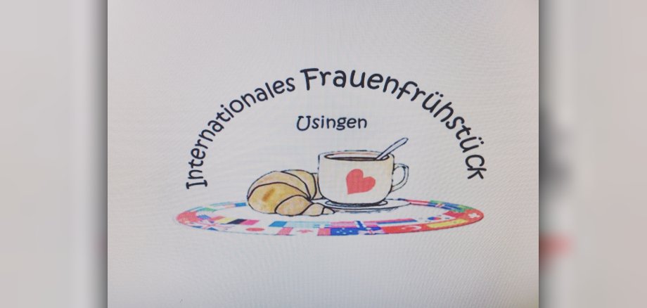 Es ist das Logo des Internationalen Frauenfrühstücks in Usingen zu sehen: Ein Croissant mit einer Kaffeetassem umgeben von einem Kreis mit verschiedenen Nationalflaggen.