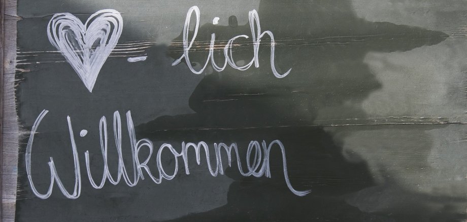 Eine Tafel mit Text: "Herzlich Willkommen"