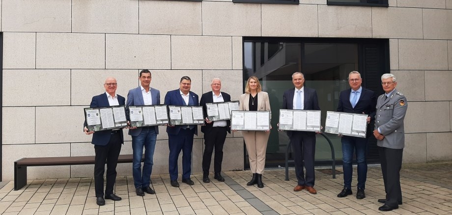 Gruppenbild mit Oberstleutnant Tilman Engel (auf dem Foto rechts) stellvertretend für den Kommandeur Herrn Brigadegeneral Bernd Stöckmann die Partnerschafts-Urkunden an Bürgermeister Roland Seel (Gemeinde Grävenwiesbach), Bürgermeister Birger Strutz (Stadt Neu-Anspach), Bürgermeister Götz Esser (Gemeinde Weilrod), Bürgermeister Gregor Sommer (Gemeinde Wehrheim), Bürgermeisterin Julia Krügers (Gemeinde Schmitten), Bürgermeister Steffen Wernard (Stadt Usingen) und Bürgermeister Thomas Ciesielski (Gemeinde Glashütten, v.l.n.r.).