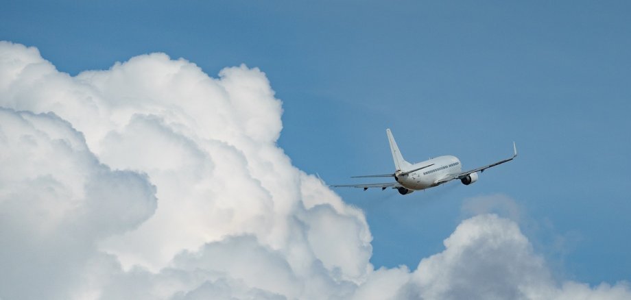 Ein Flugzeug und eine Wolke im Himmel.