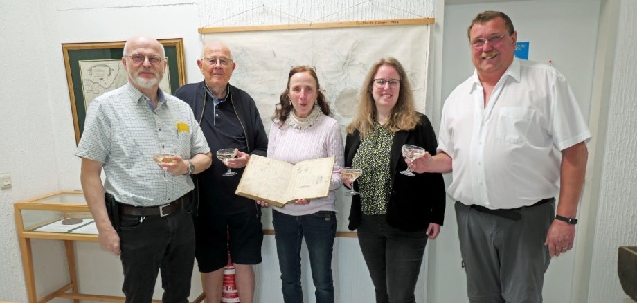 Zu sehen sind Vertreter des Stadtarchivs und des Geschichtsvereins mit einer Vertreterin der Stadtverwaltung und der Restauratorin bei der Übergabe des restaurierten Flurbuchs im Usinger Stadtarchiv.