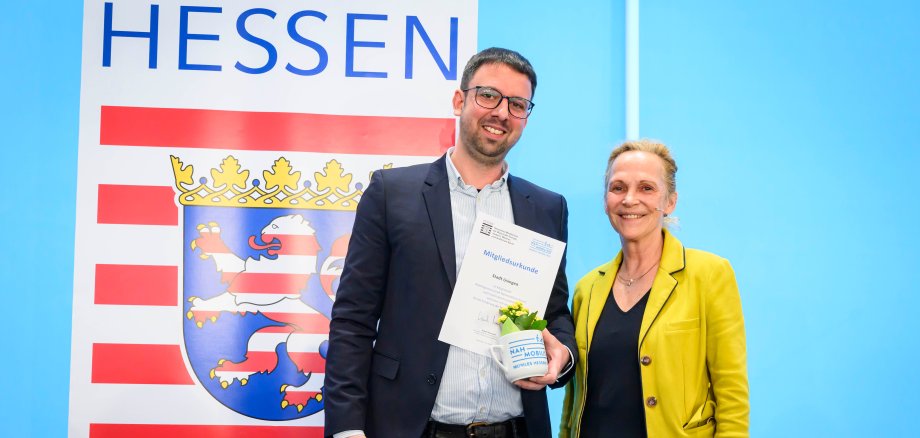 Staatssekretärin Ines Fröhlich überreicht die Mitgliedsurkunde stellvertretend an Usingens Klimaschutzmanager Fabian Wagenbach im Rahmen des Nahmobilitätskongresses 2025