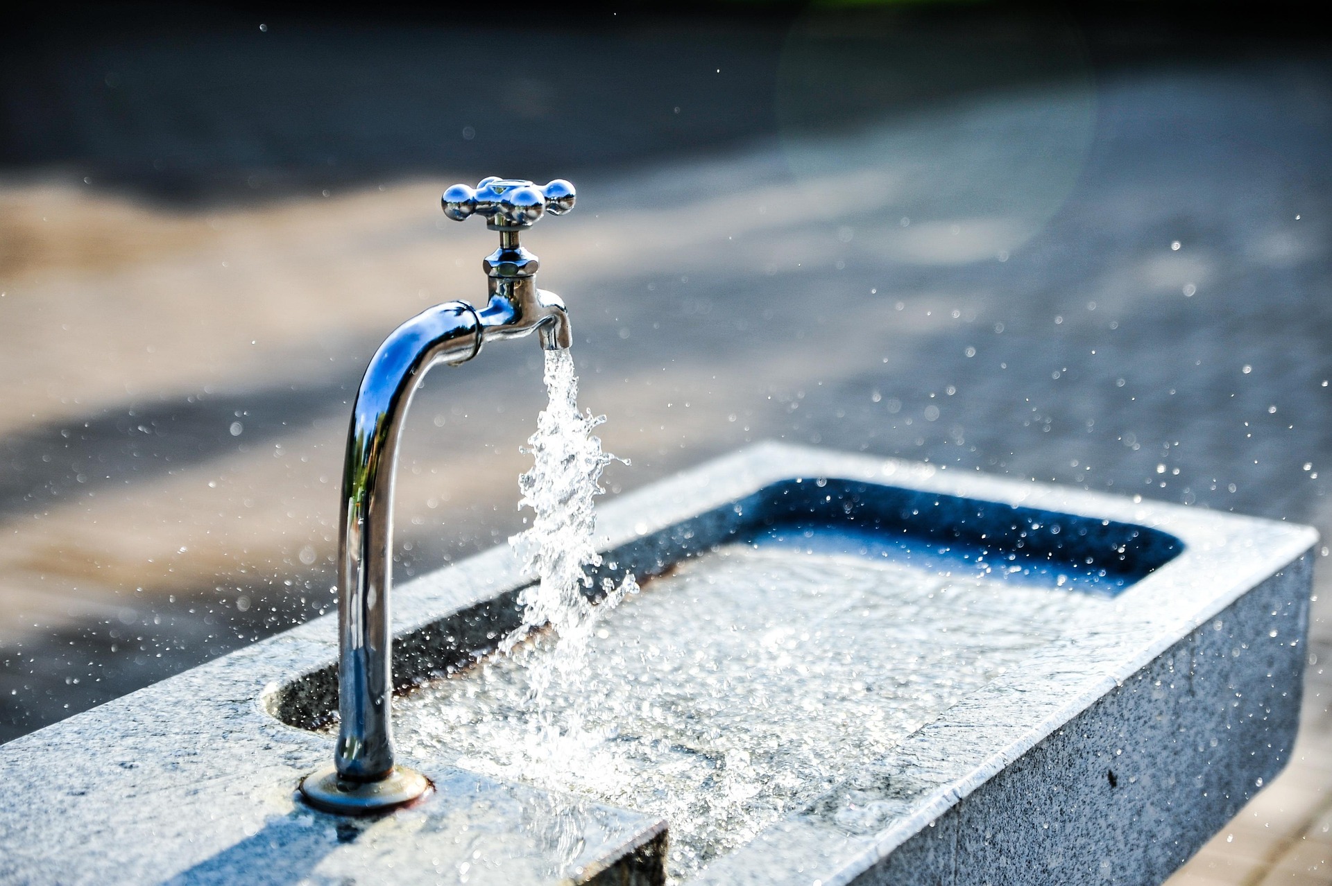 Sprudelnder Wasserhahn in einer Stadtumgebung
