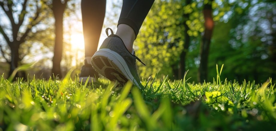 Fitness Eine Person, die auf einer grünen Wiese läuft.