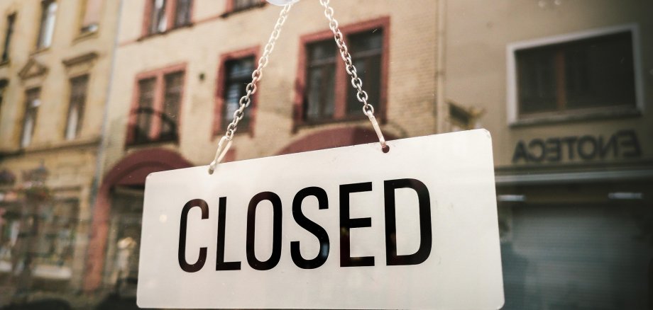 Schild in einem Schaufenster mit der Aufschrift "Closed".