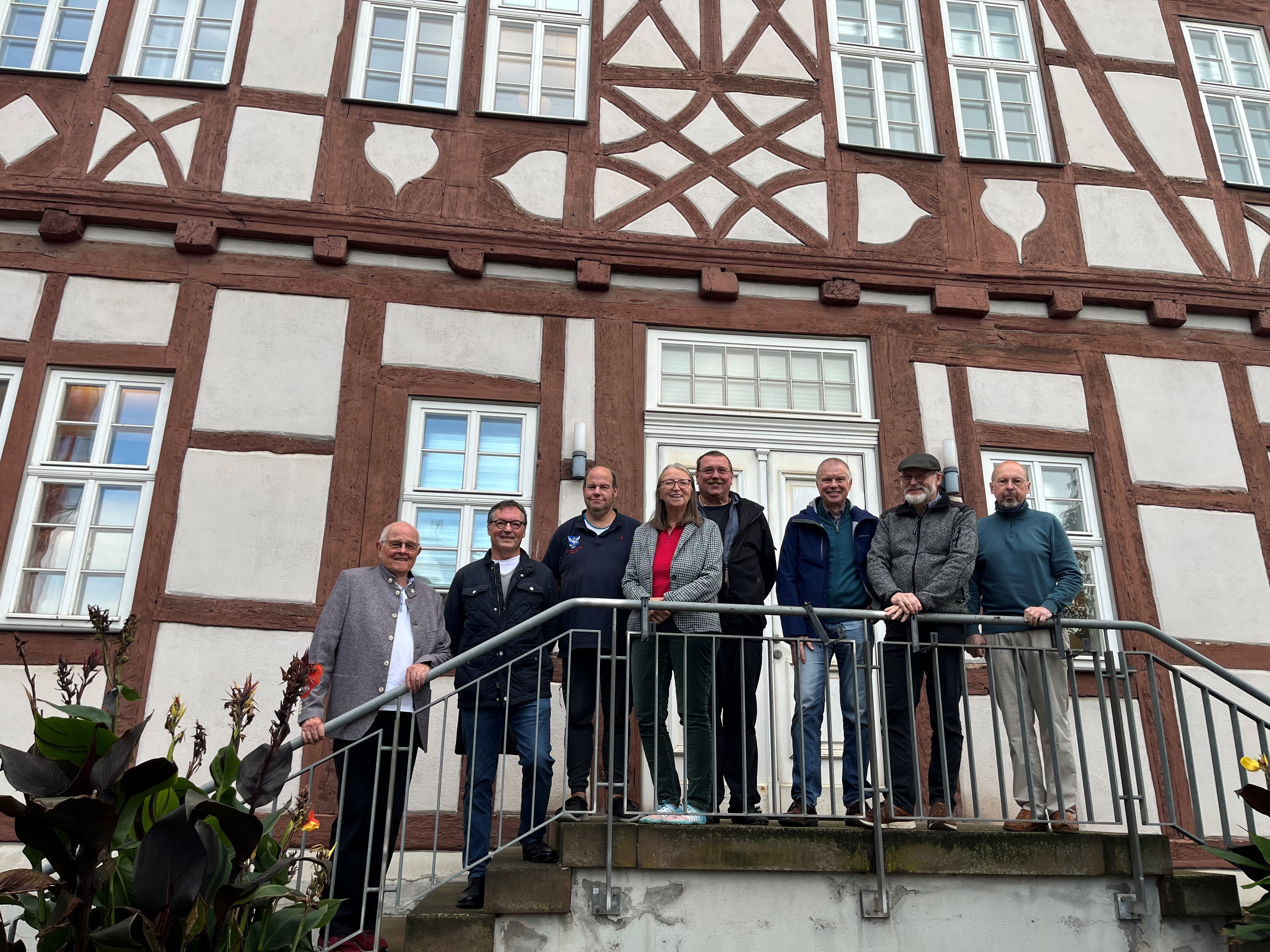 Die Stadtführerinnen und Stadtführer stehen auf der Treppe vor dem Usinger Rathaus.