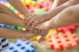 Handschlag Sieben Kinderhände schlagen ein.